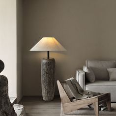 a living room filled with furniture and a lamp on top of a wooden table next to a couch