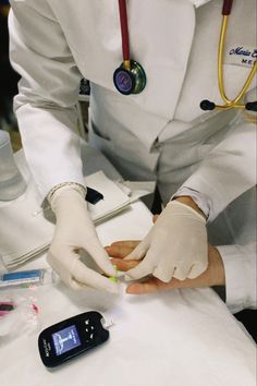 a person in white lab coat and gloves doing something on a table with other medical equipment