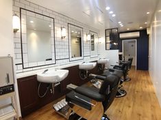 a hair salon with chairs, mirrors and sinks on the wall in front of them