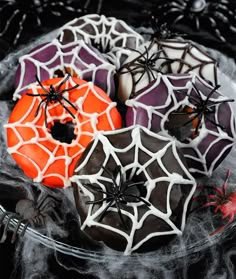 decorated donuts with spider webs and spooky eyes in a glass bowl