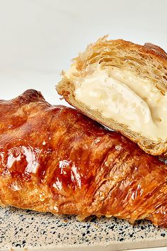 two croissants with butter on them sitting on top of each other in front of a white background