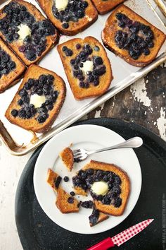 blueberry french toast with butter and syrup on a plate next to a baking pan