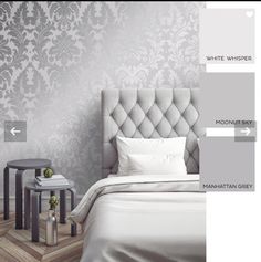 a bedroom with white and grey wallpaper, bedding and pillows