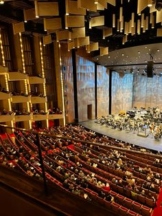 an auditorium filled with people sitting and standing