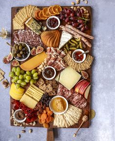 an assortment of cheeses and meats on a wooden platter