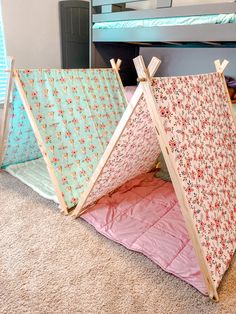 two teepee tents sitting next to each other on top of a carpeted floor