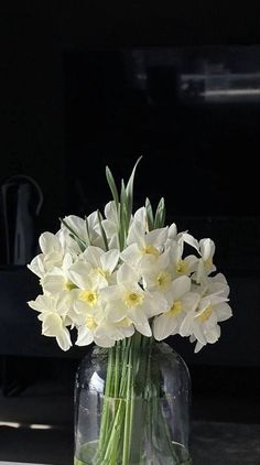 a vase filled with white flowers sitting on top of a table