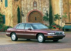 a maroon car parked in front of a house