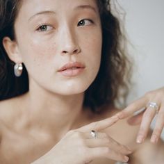 a woman in white dress holding onto her ring