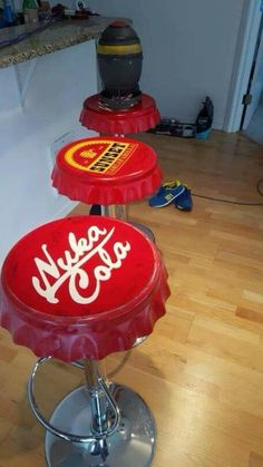 two coca - cola stools sitting on top of a hard wood floor