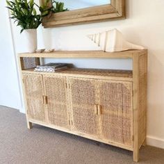 a wooden cabinet sitting next to a wall with a mirror on it's side