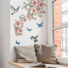 a window sill with flowers and butterflies painted on the wall next to a pillow