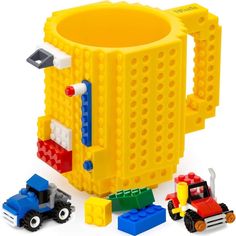 a lego coffee mug with construction vehicles around it