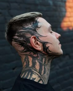 a man with tattoos on his face and neck