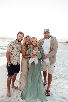 a family posing for a photo on the beach