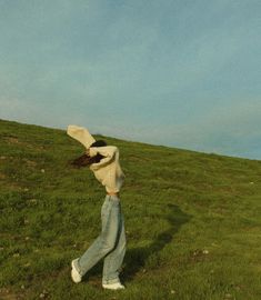 a woman standing on top of a lush green field