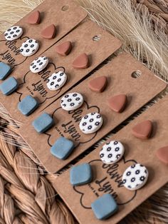 some brown and blue buttons are laying on top of each other in a basket next to straw