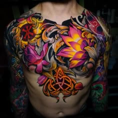 a man's chest covered in tattoos and flowers