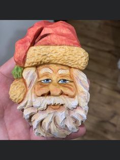 a close up of a person holding a small figurine with a hat on