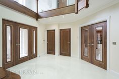 an empty room with wooden doors and windows