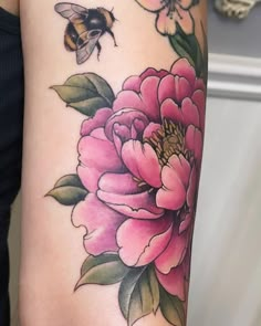 a woman's arm with flowers and a bee on it