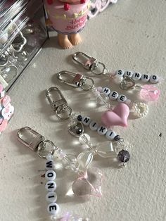 several key chains with charms attached to them sitting on a table next to a mirror