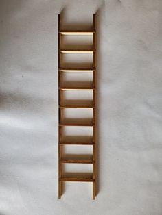 a wooden ladder leaning up against a white wall