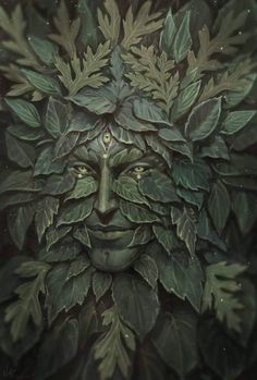 a green man's face surrounded by leaves