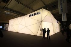 two people are standing in front of a samsung booth at an expo or showroom