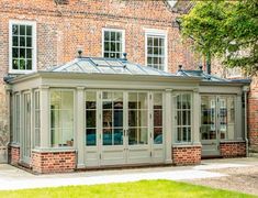 an orangery in front of a brick building