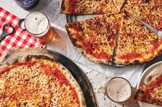 several pizzas and beer on a table