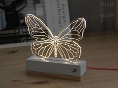 a light up butterfly sitting on top of a wooden table