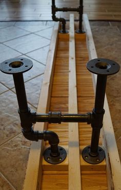 two pipes are connected to each other on the floor in front of a tile floor