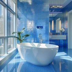 a bathroom with blue tiles and a white bathtub in the middle of the room