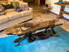 a living room with couches and a table in the middle of it on top of a blue rug