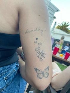 a woman with a tattoo on her arm that reads daddy and has a butterfly in it