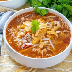 a white bowl filled with chicken tortilla soup and garnished with cilantro