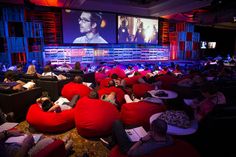 people are sitting in bean bags and watching movies on the big screen at an event