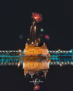 fireworks are lit up in the night sky above a building with water and lights on it