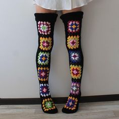 the legs of a woman wearing colorful crocheted socks and knee - high socks