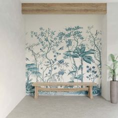 a wooden bench sitting in front of a wall covered in blue and white floral designs