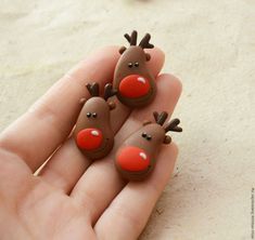 two tiny reindeer figurines sitting on top of someone's hand