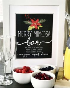 three bowls filled with berries and raspberries on top of a table next to two wine glasses