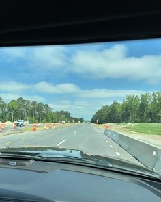 the view from inside a car looking at construction on the side of the road and traffic cones