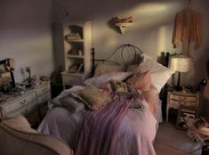 a bedroom with an old fashioned bed and lots of clutter