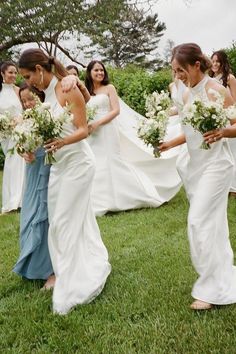 a group of bridesmaids walking in the grass