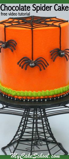 an orange cake decorated with black spider webs and green icing on a wire stand