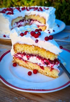 there is a piece of cake with white frosting and cranberries on it