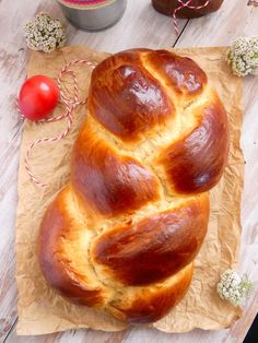 a loaf of bread sitting on top of a piece of wax paper next to some flowers