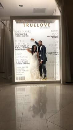 a man and woman standing in front of a truelove advertisement on the wall